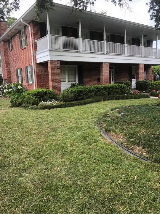 Freshly maintained lawn around a brick home