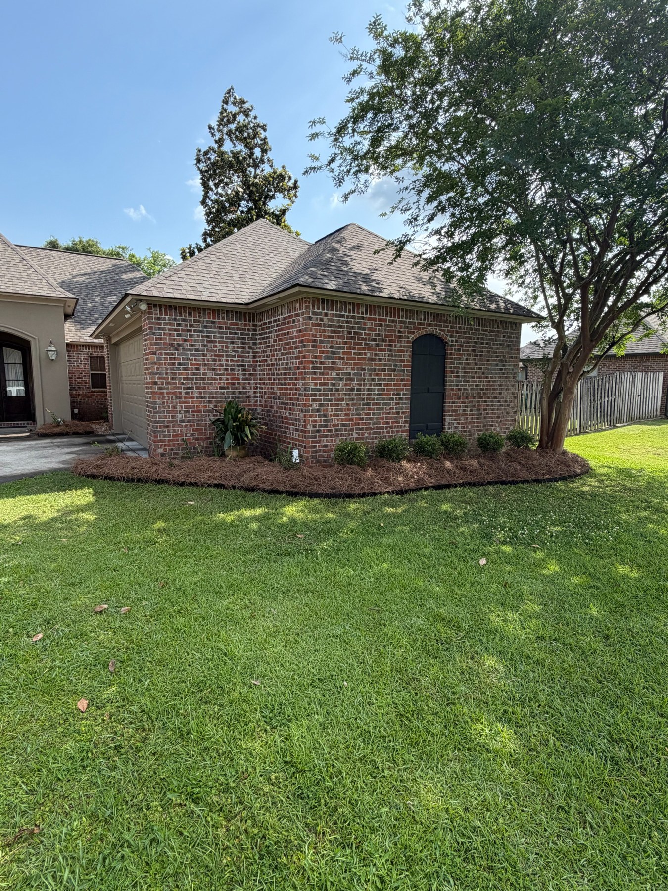 Freshly installed landscape bed wrapping a brick home